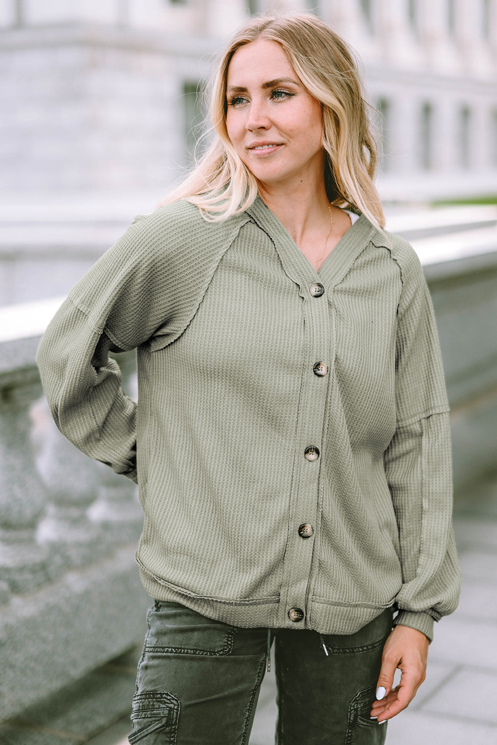 Cardigan vert en tricot gaufré avec boutons et coutures apparentes sur le devant