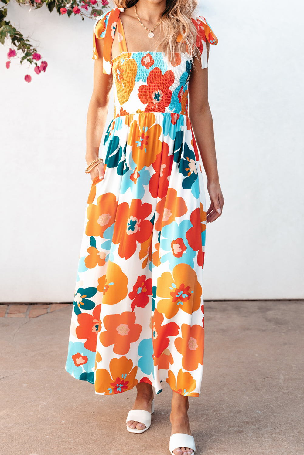 Robe longue orange à fleurs et bretelles nouées au buste smocké