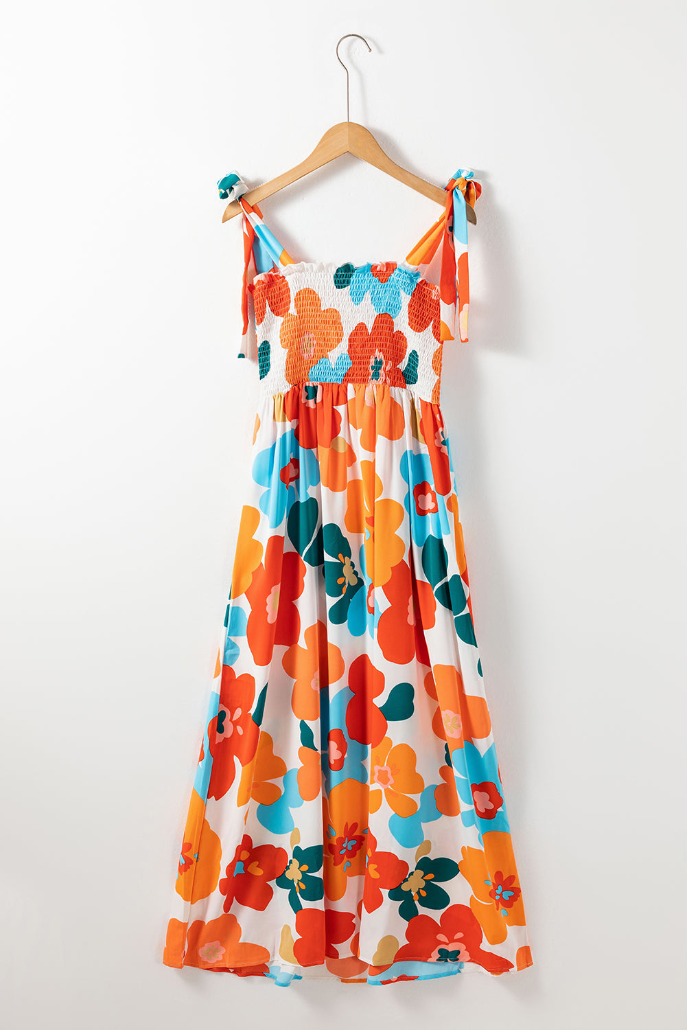 Robe longue orange à fleurs et bretelles nouées au buste smocké