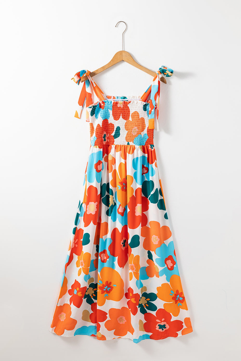 Robe longue orange à fleurs et bretelles nouées au buste smocké