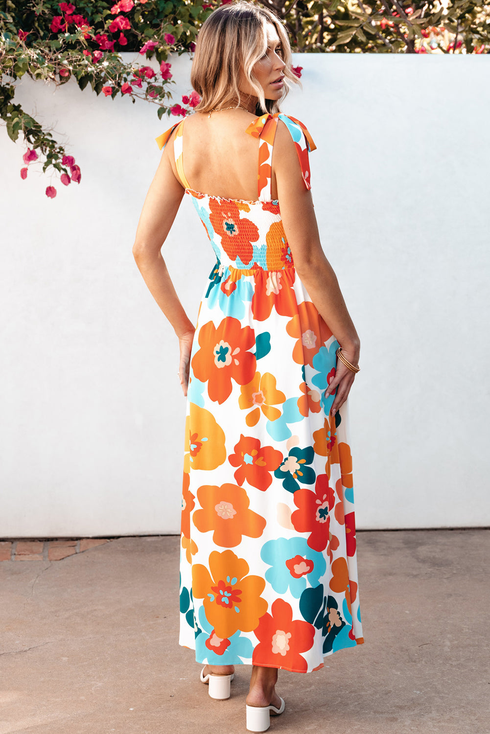 Robe longue orange à fleurs et bretelles nouées au buste smocké