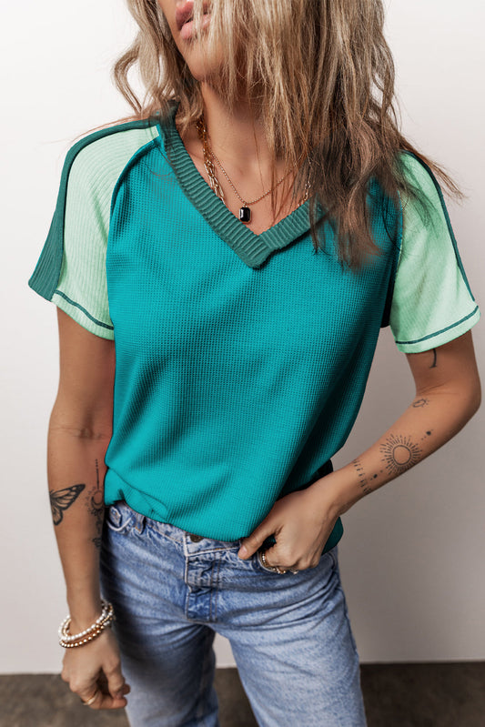 T-shirt tricoté vert à col en V et coutures apparentes
